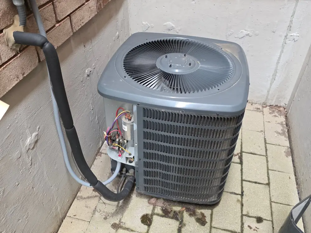 Air conditioner condenser with the electrical access panel removed during a service call